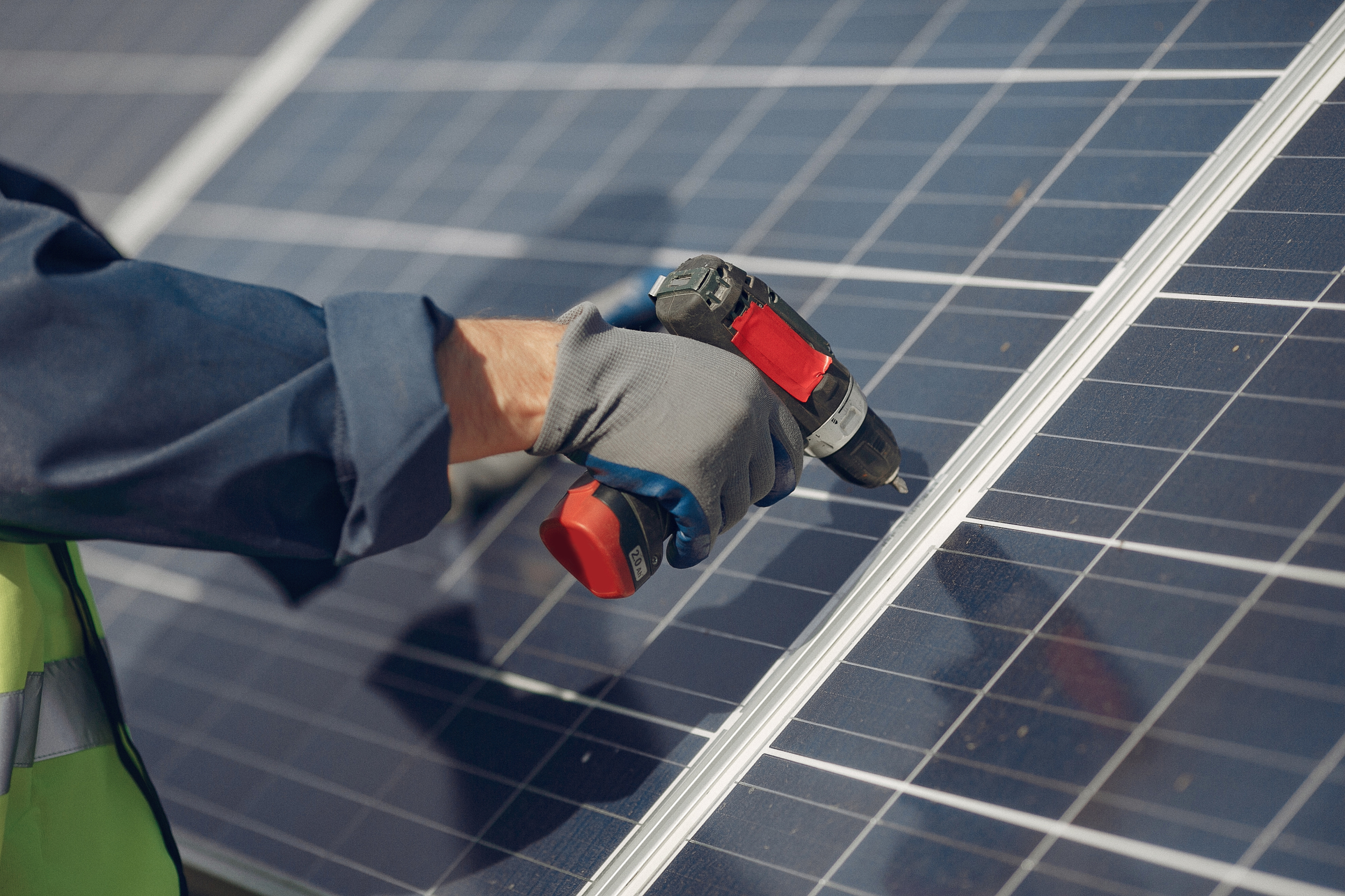 man with white helmet near solar panel scaled